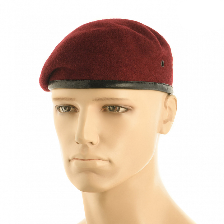 A dark red wool beret with a black leather-like band, displayed on a beige mannequin head against a plain white background.