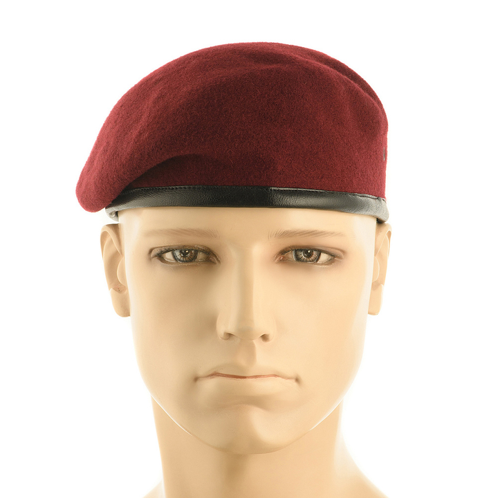 A maroon wool beret with a black leather-like band, displayed on a mannequin head against a plain white background.