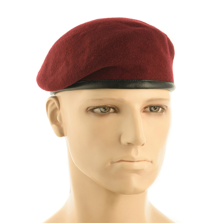 A maroon wool beret with a black leather trim band, displayed on a mannequin head against a white background.