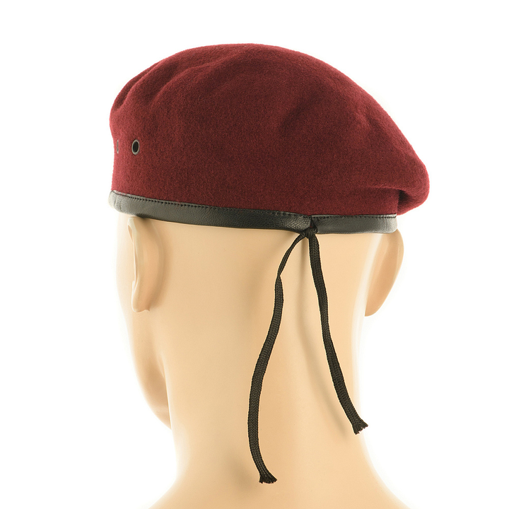 A maroon felt military beret with a black leather-like trim and black chin strap, displayed on a beige mannequin head against a white background.