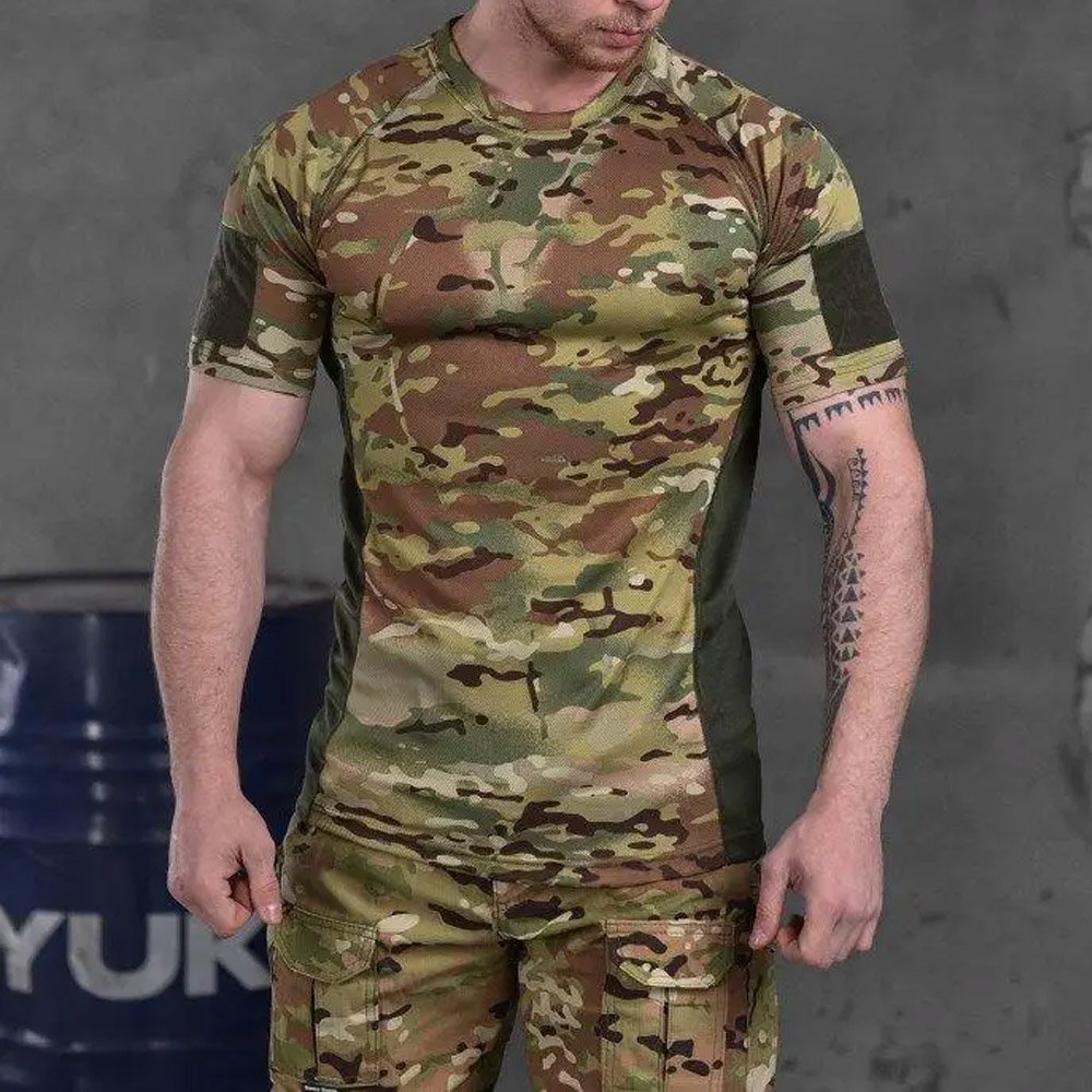 Front view of a muscular man wearing a Multicam tactical t-shirt, showcasing its ergonomic fit and breathable panels.