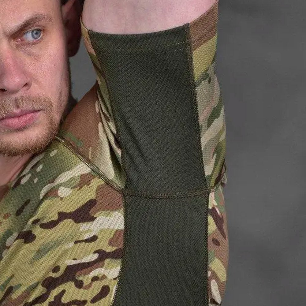 Close-up of a man lifting his arm, showing the breathable mesh underarm panel of a Multicam tactical t-shirt.