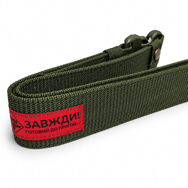 Olive green tactical waist belt showing the thick nylon webbing and red manufacturer label stitched onto the outer side.