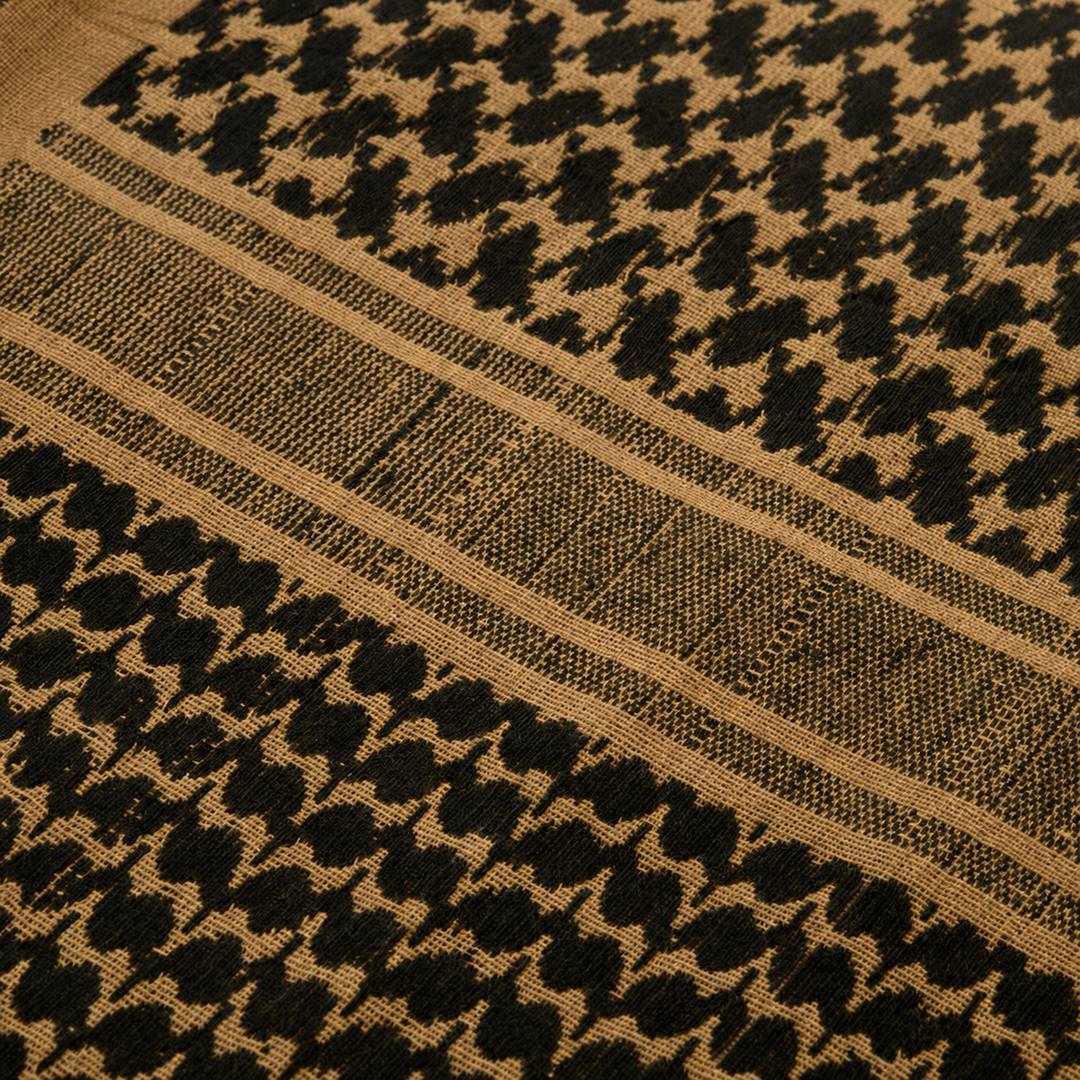 Close-up texture of woven coyote tan and black cotton tactical shemagh fabric