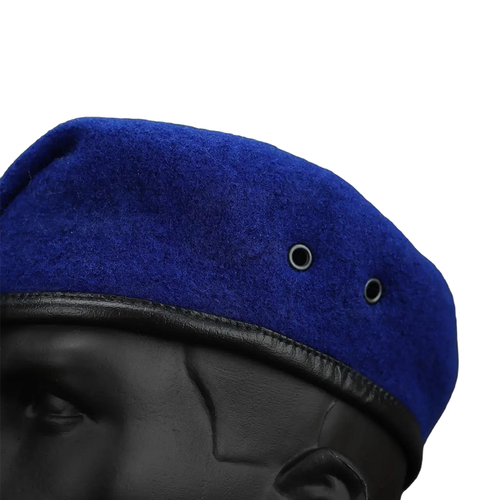 Close-up texture of royal blue wool military beret with dual metal ventilation eyelets