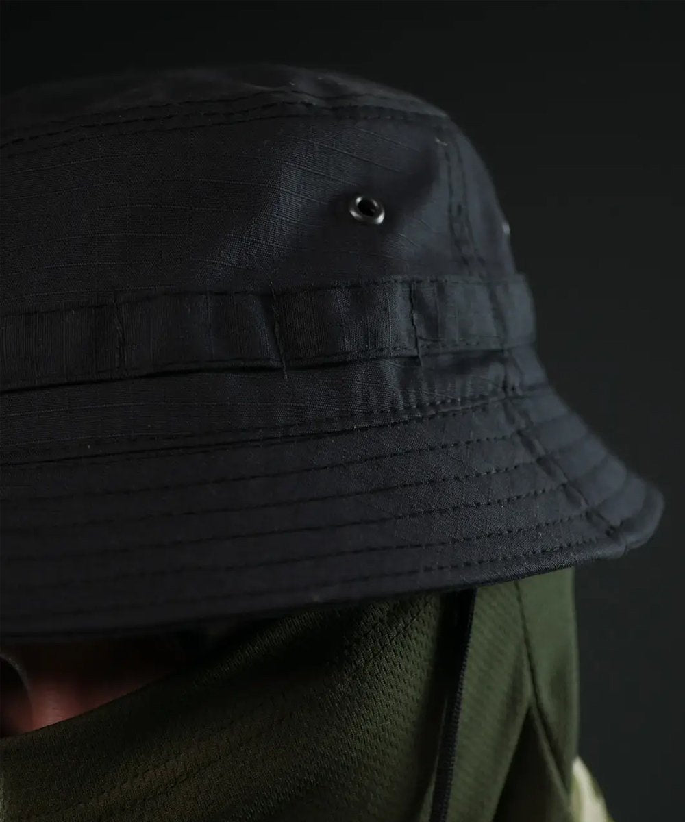 Front view of black bush hat with MOLLE and chin strap worn with face mask