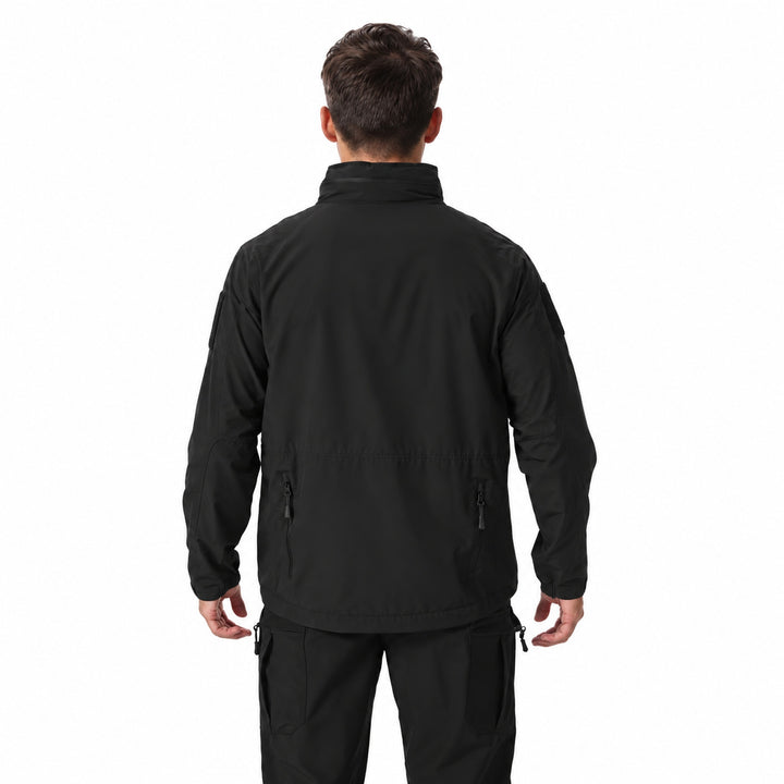 Black waterproof tactical jacket worn from the back, showing the raised collar, clean rear construction, sleeve hook &amp; loop panels, and adjustable cuffs.