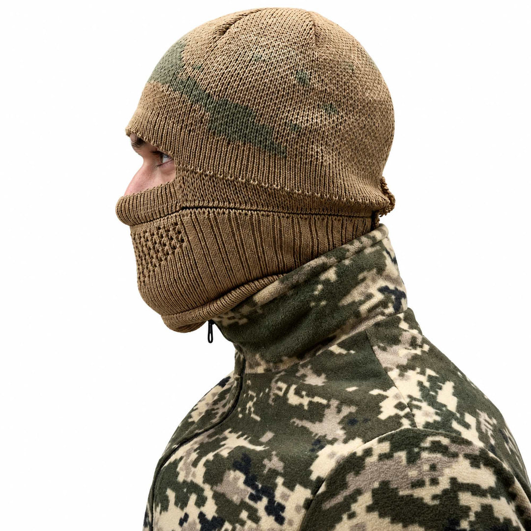 Khaki wool balaclava covering the head, nose, mouth, and neck with a single eye opening and open-knit breathing section over the lower face.