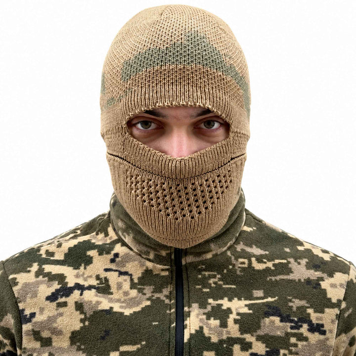 Knitted military balaclava worn fully over the head and face, with a wide eye opening, ventilated knit around the mouth, and khaki camouflage pattern across the top.