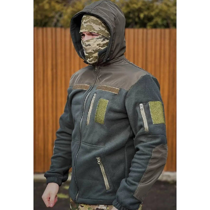 Full view of a man wearing a hooded military fleece jacket in olive.