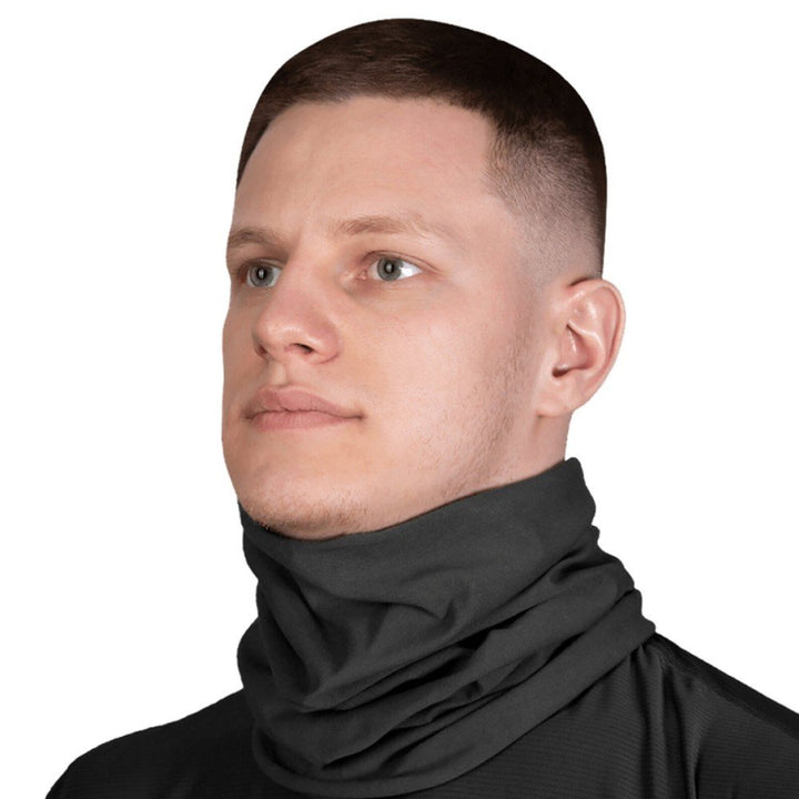 Man wearing a black tactical tube scarf, ideal for protection in outdoor activities.