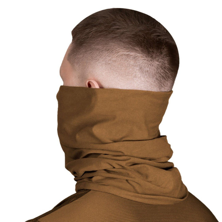 A man wearing a coyote tactical neck gaiter for warmth and protection.