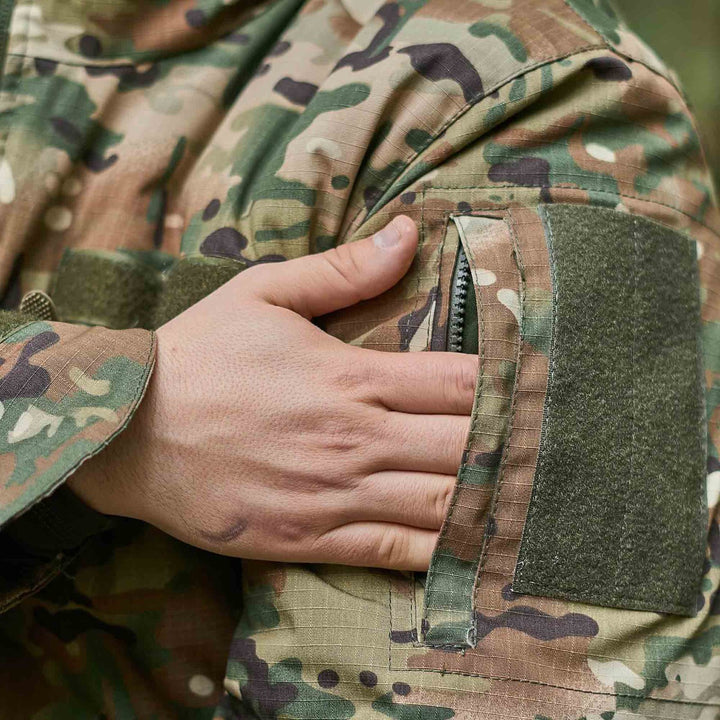 Close-up of a zippered arm pocket on a multicam tactical jacket, providing secure storage for gear and essentials.