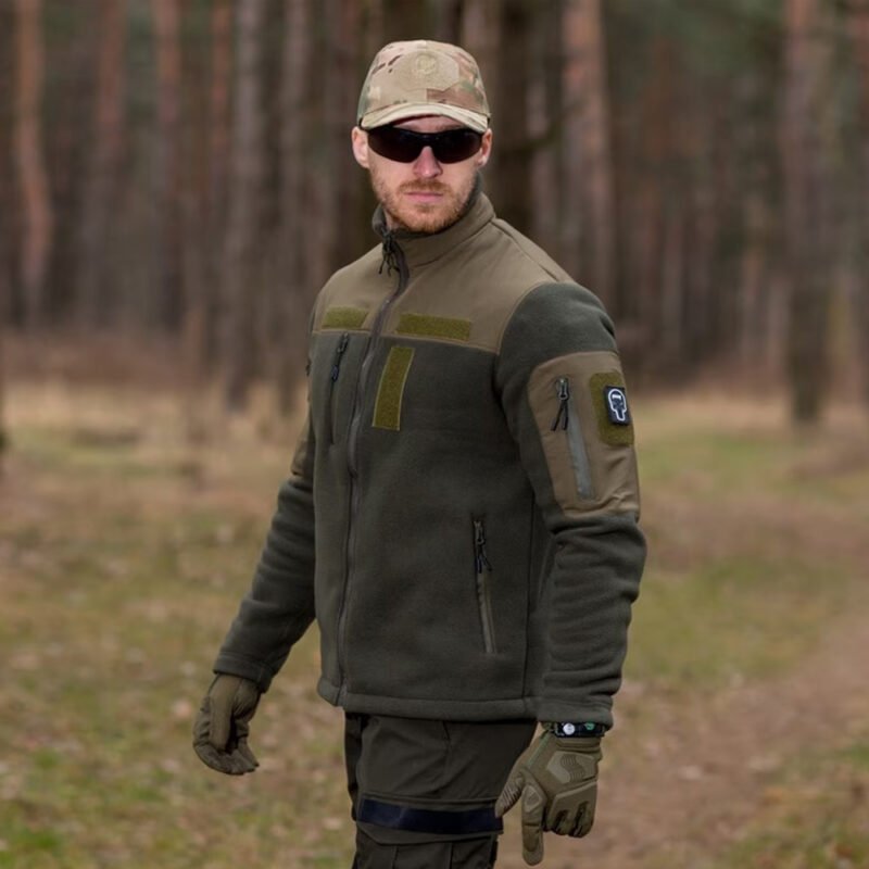 Frontal view of a man wearing a khaki tactical fleece jacket with sunglasses.