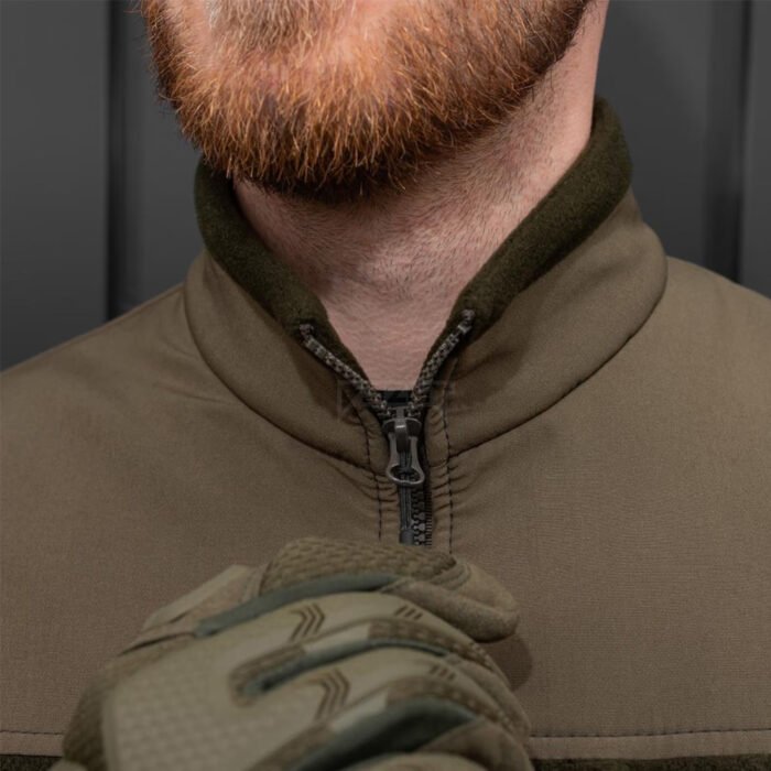Detailed view of a khaki colored fleece jacket collar and zipper.