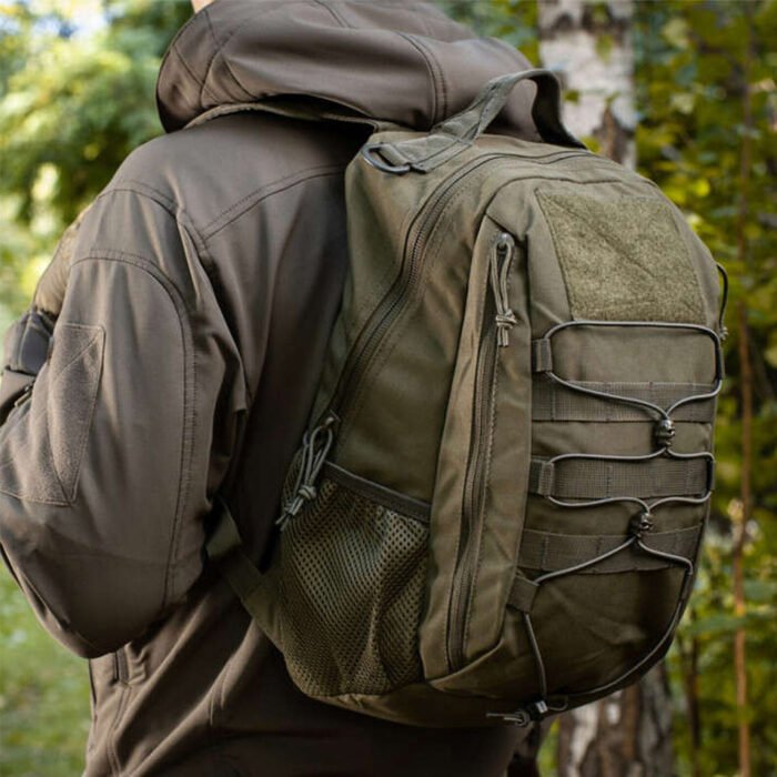 Person wearing olive tactical backpack outdoors