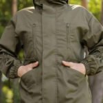 Olive tactical gorka jacket showcasing utility pockets and elastic cuffs for military personnel.