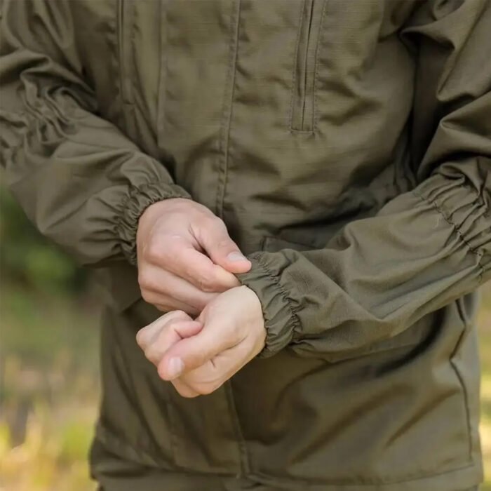 Close-up of the sleeve of an olive Gorka tactical jacket, showcasing adjustable cuffs.