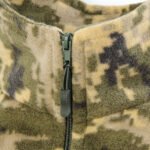 Zipper pull close-up on a tactical camo jacket.