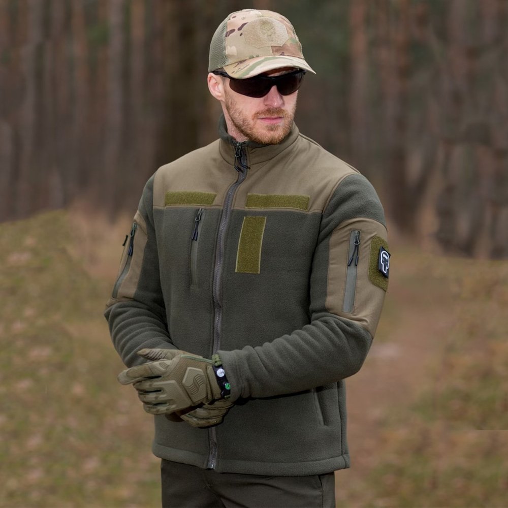 Man wearing a khaki fleece jacket with a full zip closure, suitable for military use and outdoor activities.