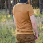 Rear view of a man wearing a coyote brown t-shirt outdoors.