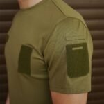 Close-up view of the shoulder and sleeve of an olive green t-shirt showing Velcro patches
