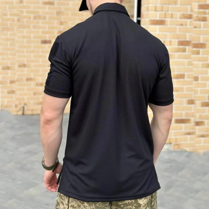 Rear view of a black tactical polo shirt worn by a man.