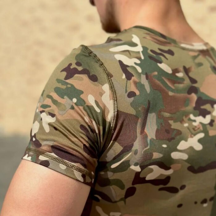 Close-up of a multicam camouflage pattern on a fitted t-shirt, highlighting the detailed textures and colors.
