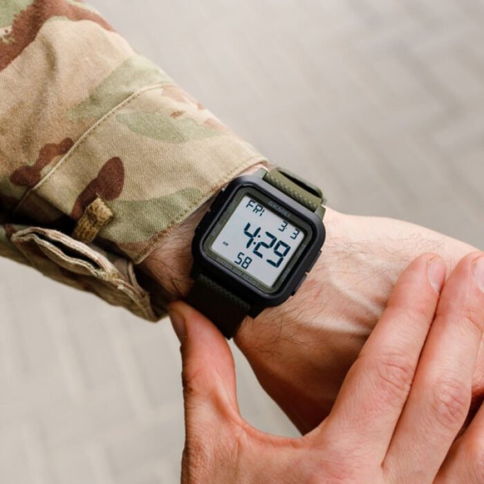 Man wearing Skmei tactical digital wristwatch with green strap, displaying the clear digital interface with time and date.