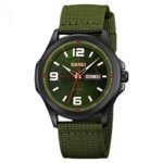 A green-faced tactical wristwatch with black steel casing and durable green fabric strap, displaying the day and date. Designed for rugged conditions and outdoor adventures.