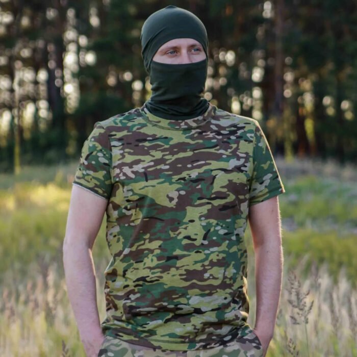 Man in multicam t-shirt and balaclava facing forward in a forest.