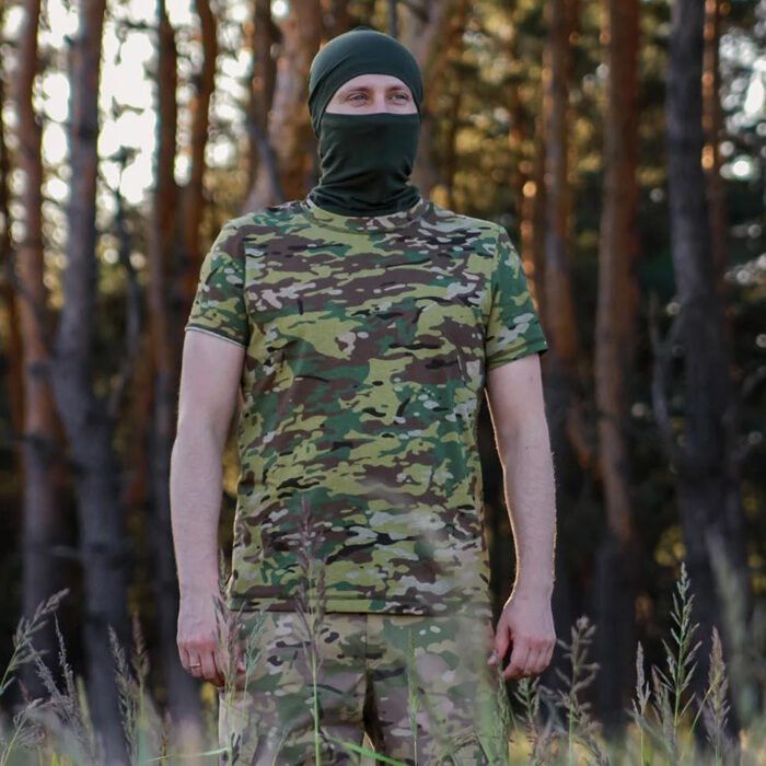 Front view of a man in a multicam t-shirt standing in a wooded area.