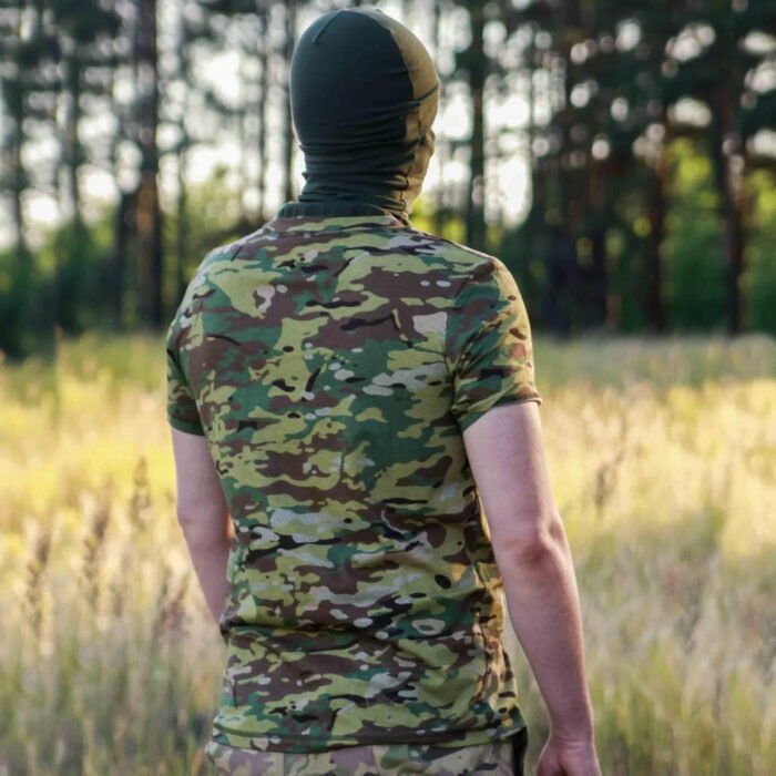 Back view of a man wearing a multicam camouflage t-shirt in a forest.