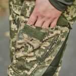 Close-up of the cargo pocket with zipper closure on military camouflage pants.