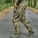 A soldier walking in MM14 pixel camouflage tactical pants with reinforced design.