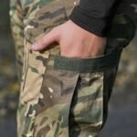 Close-up of the pocket design on multicam fleece pants with velcro fastening.