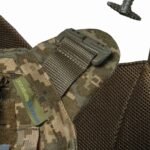 Angled view of the tactical chest armor showing MOLLE system, adjustable shoulders, and breathable mesh
