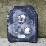 Damaged ballistic plate showing bullet impacts after laboratory test