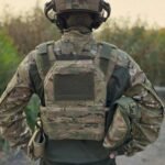 Soldier wearing multicam bulletproof vest with MOLLE webbing and shoulder risers