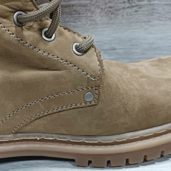 Close-up of stitching and leather texture on NATO beige combat boot