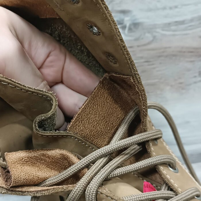 Inside view of NATO beige leather Ukrainian boot with hand showing lining